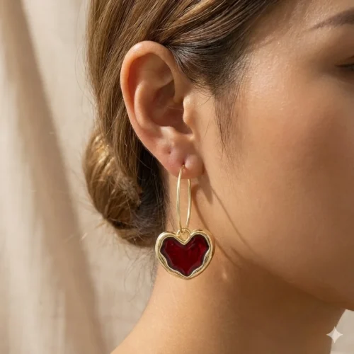 Грайливі золотисті сережки-кільця з червоним емальованим серцем та кристалом